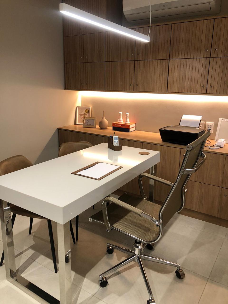 Vista do consultório com cadeiras e escrivaninha para atendimento